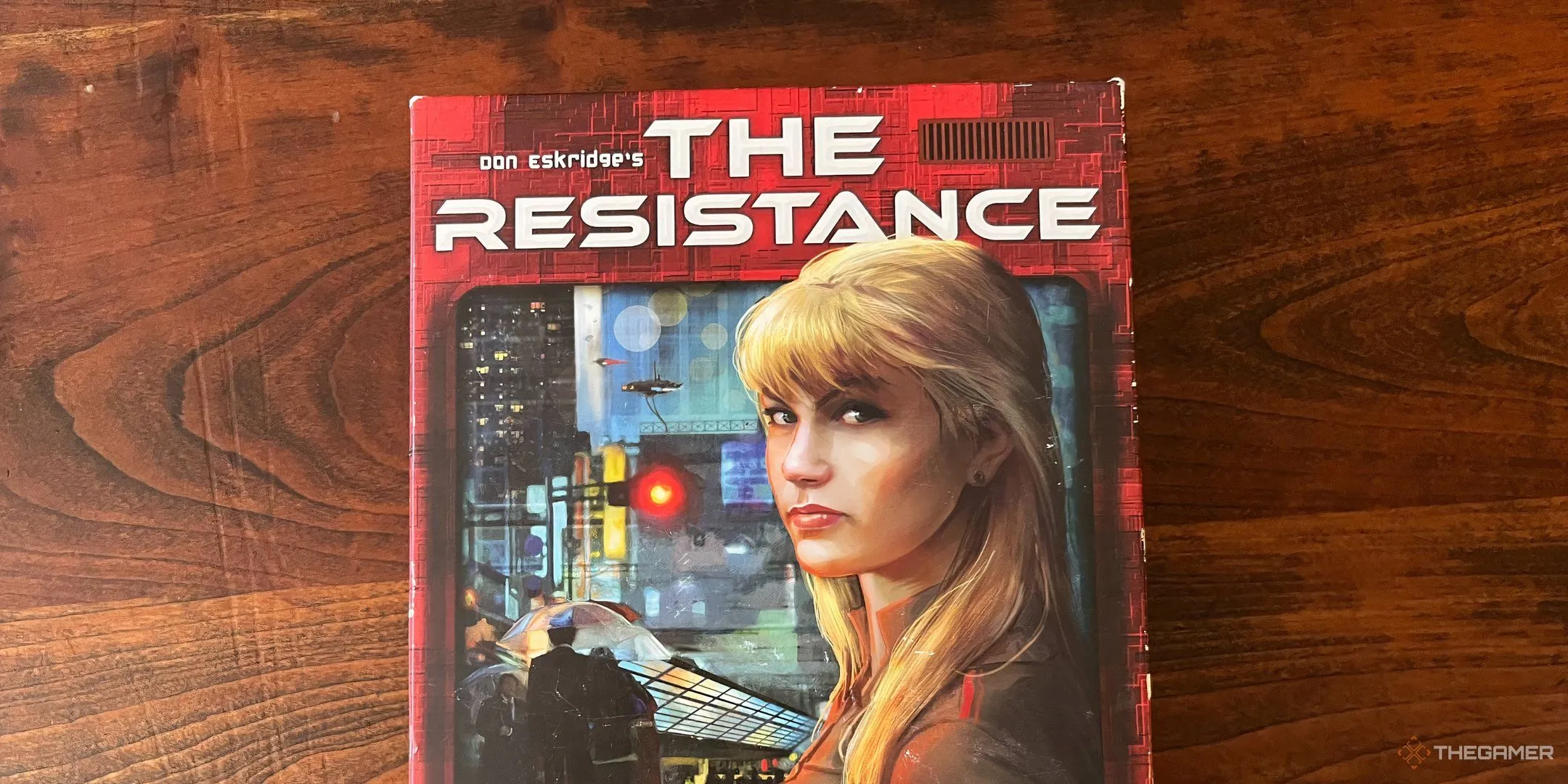 Bìa hộp board game The Resistance với hình ảnh nữ điệp viên và các biểu tượng cách mạng