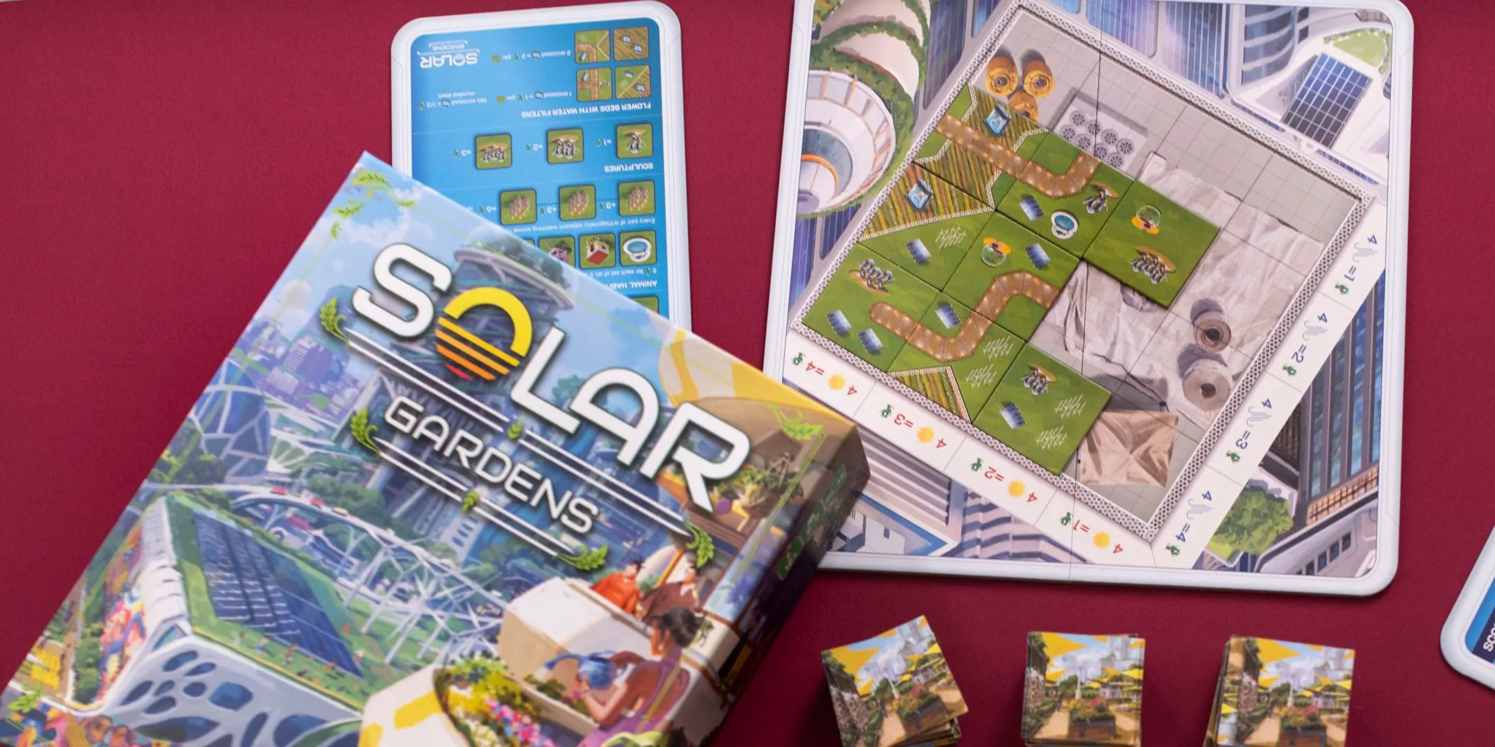 Hộp và các thành phần board game Solar Gardens được bày trên bàn chơi