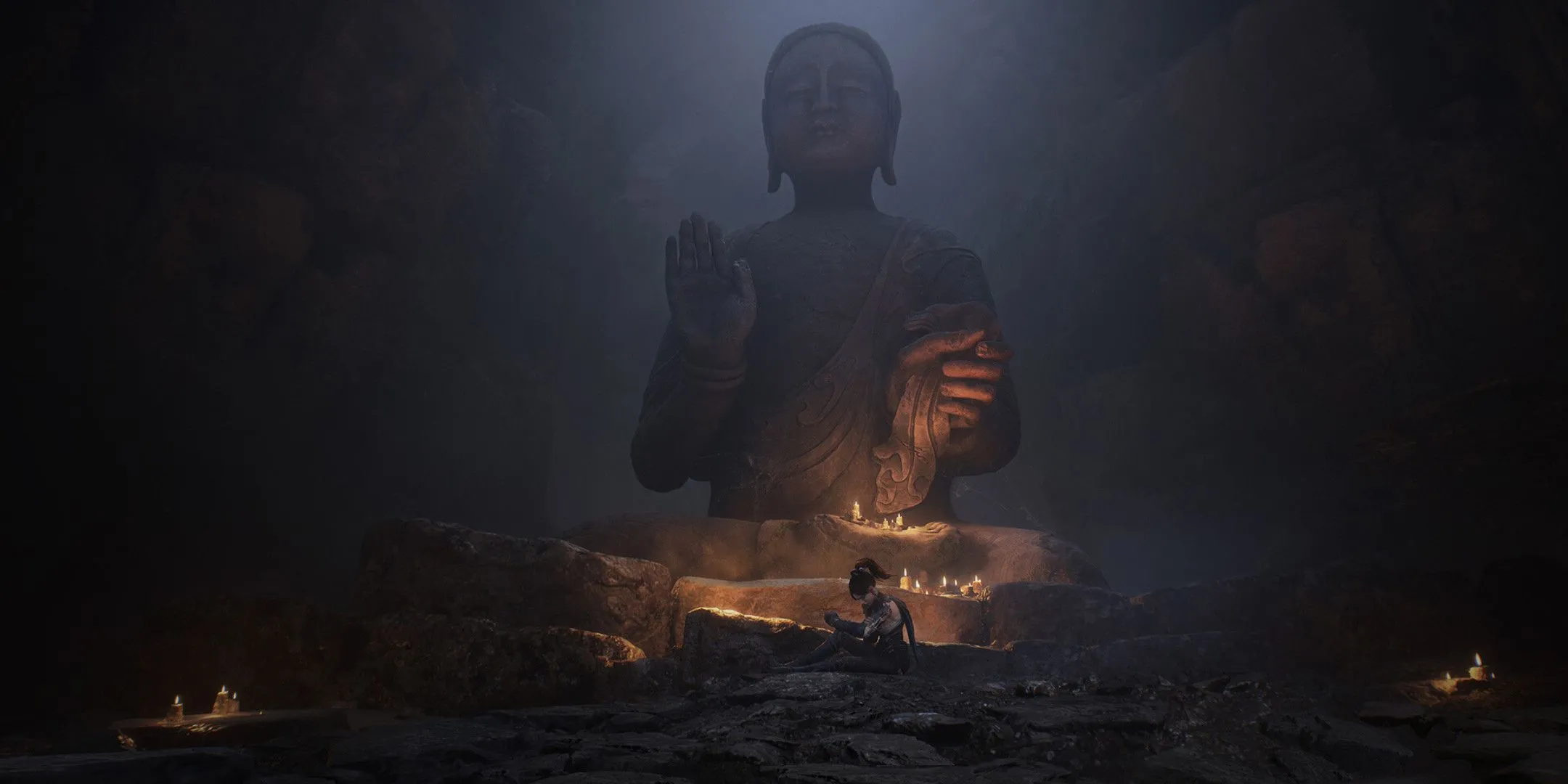 Một người phụ nữ ngồi dưới một bức tượng Phật lớn, hình ảnh mang tính biểu tượng trong cốt truyện Wuchang.