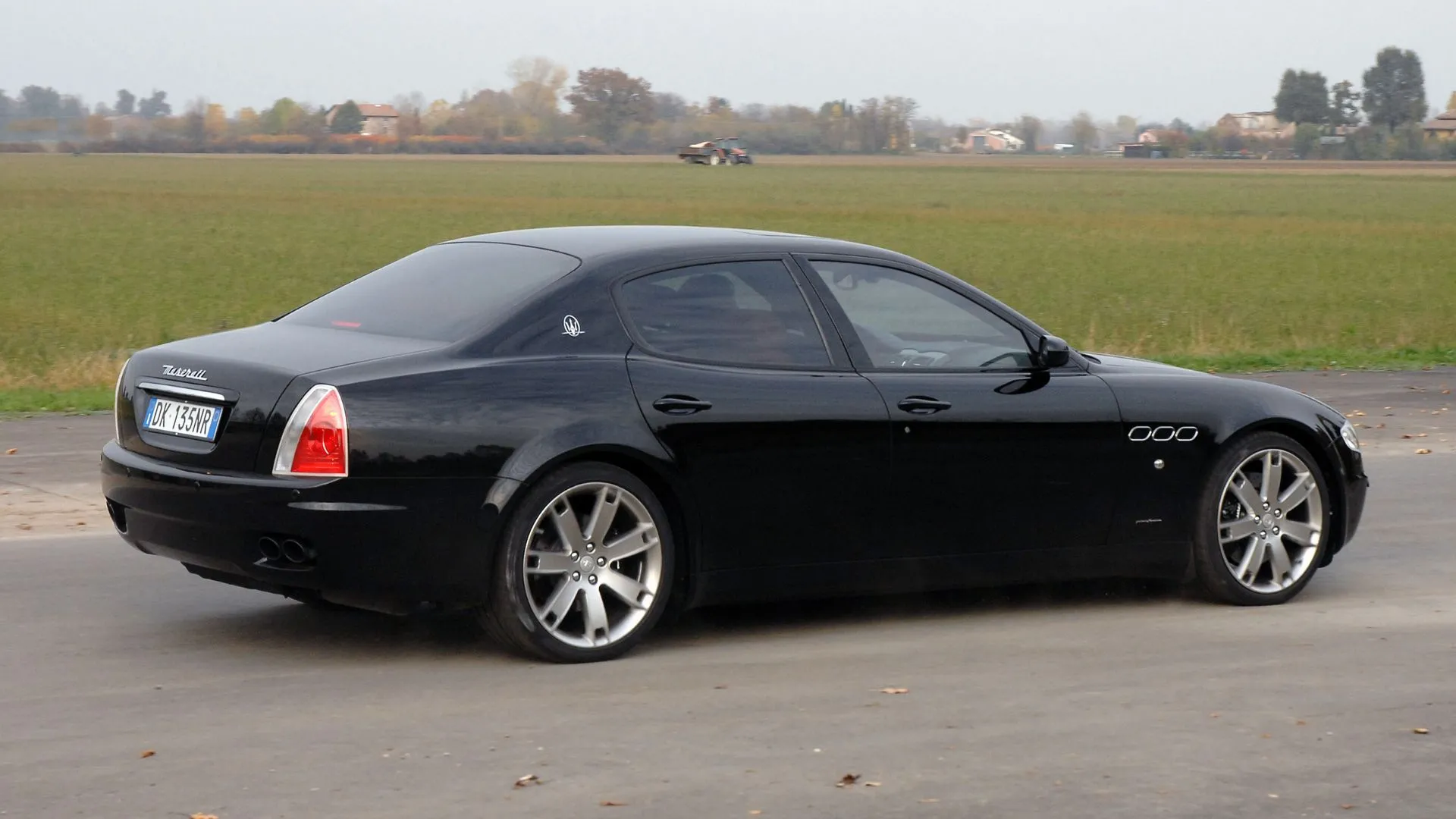 Ảnh 3/4 phía sau của Maserati Quattroporte 2007 màu đen, mô tả ngoại hình thể thao trong trạng thái tốt.