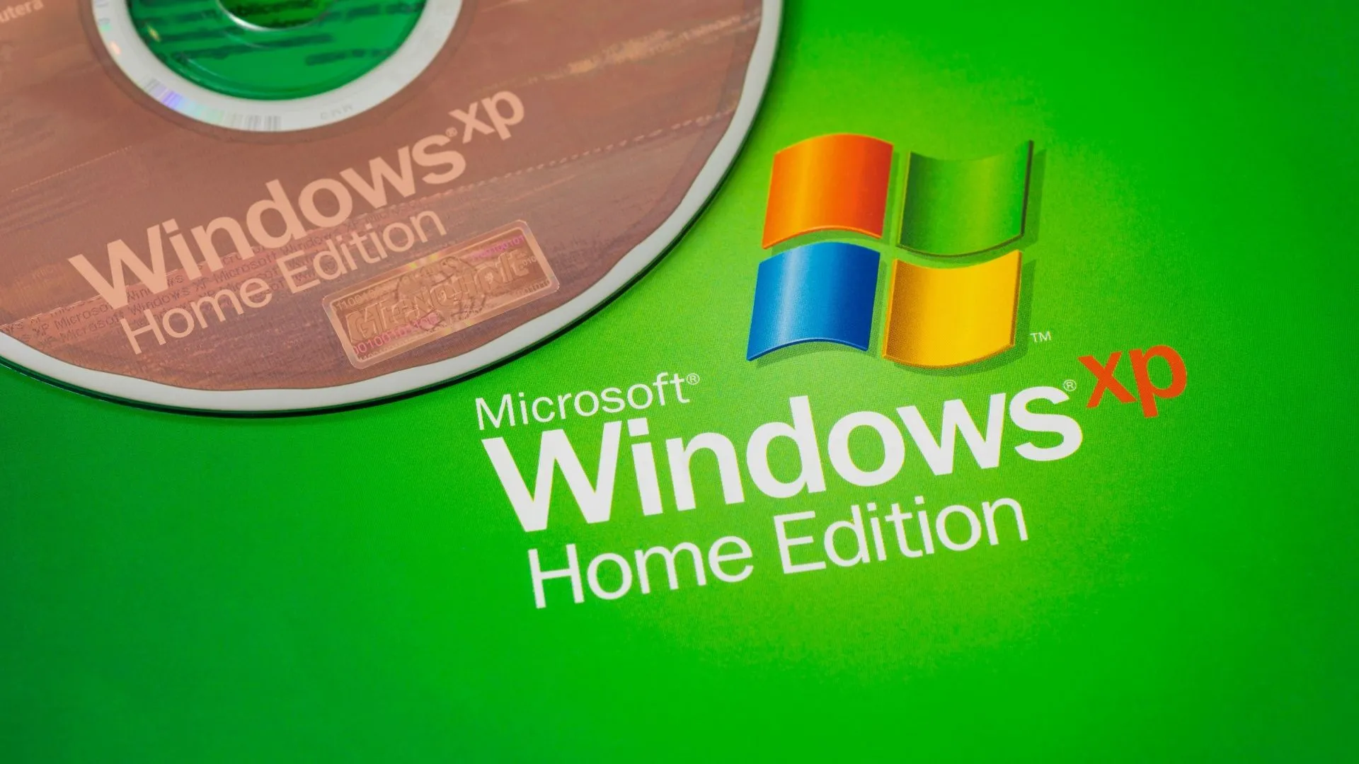 Đĩa cài Windows XP cạnh logo, biểu tượng hệ điều hành XP và di sản Windows NT