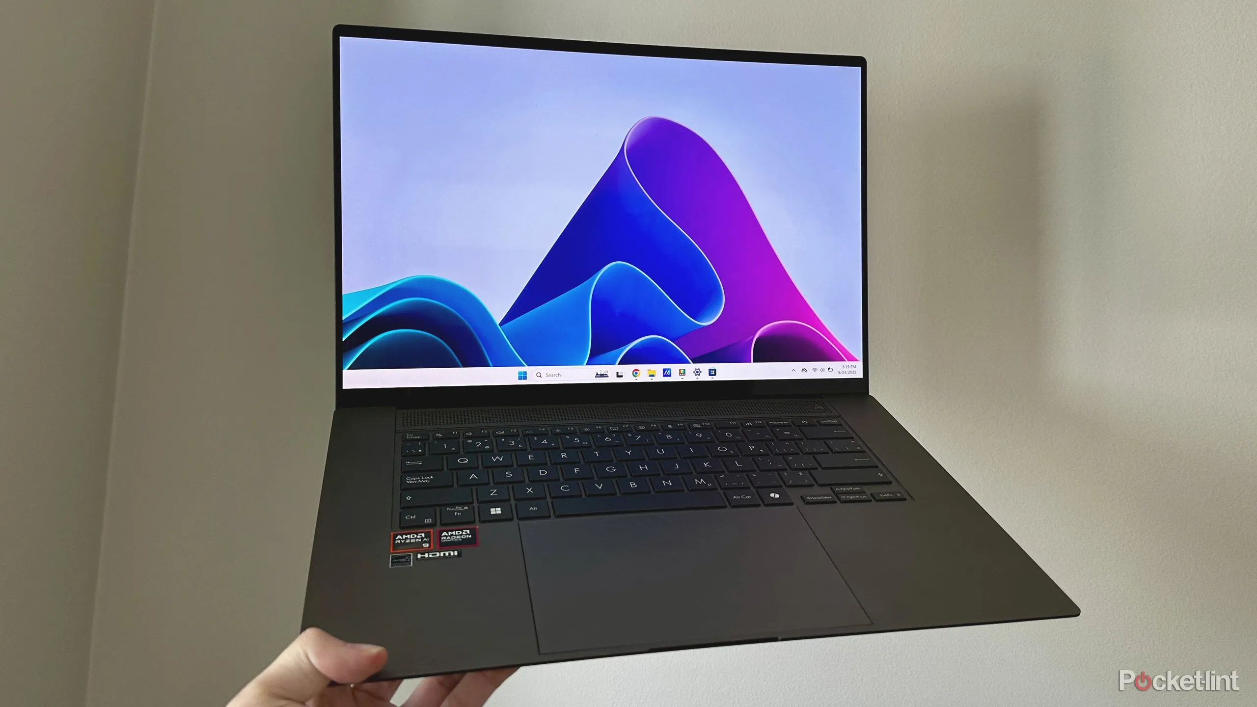 Laptop Windows 11 được cầm lên, nhấn mạnh các tính năng nhỏ nhưng hữu ích như Snap Layouts và DirectStorage
