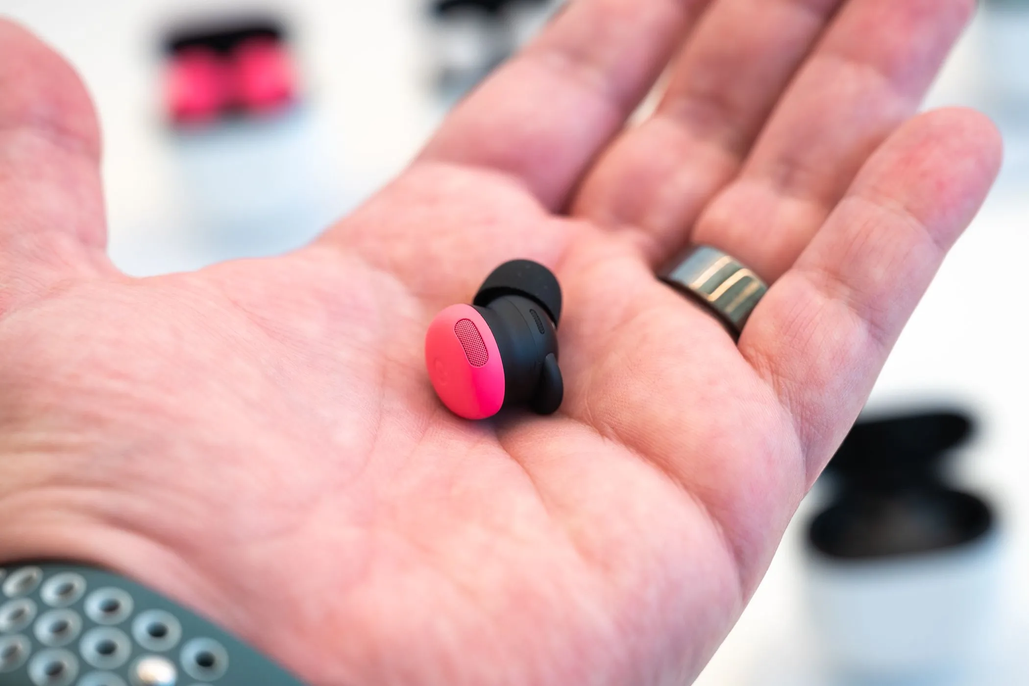 Người cầm tai nghe Google Pixel Buds Pro 2 màu Peony, liên quan tới trải nghiệm âm thanh khi chơi game và voice chat